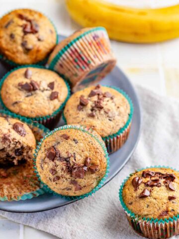 chocolate chip muffins in a plate with banana aside